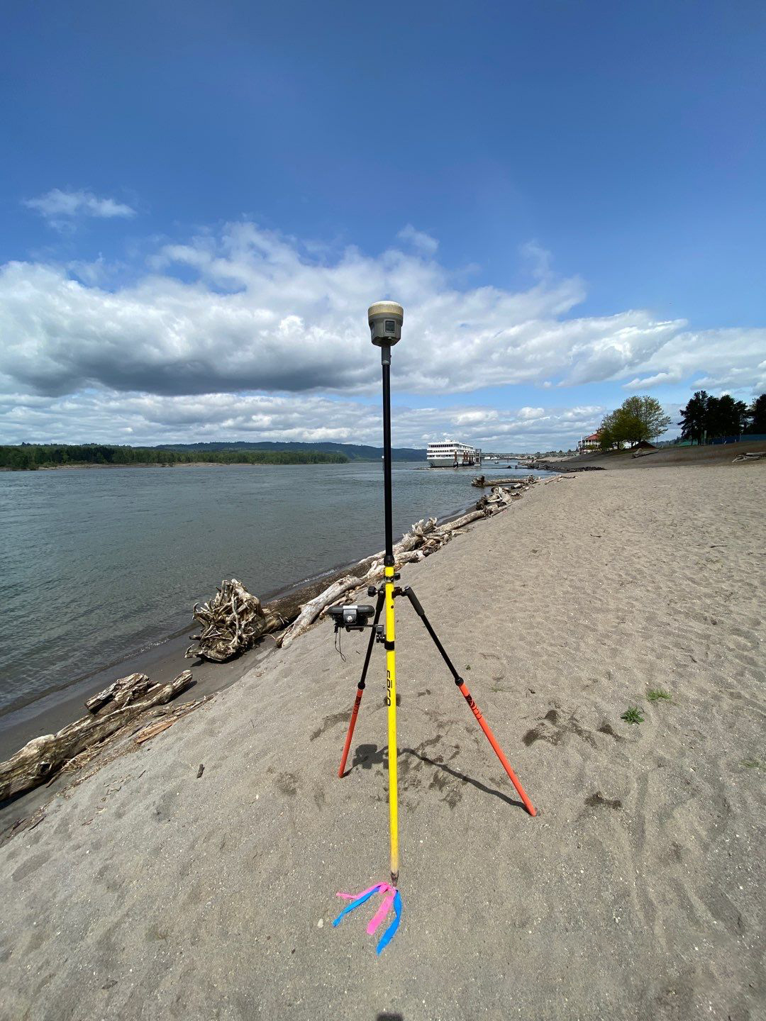 Hydrographic surveying equipment set up on a sandy shore next to a body of water