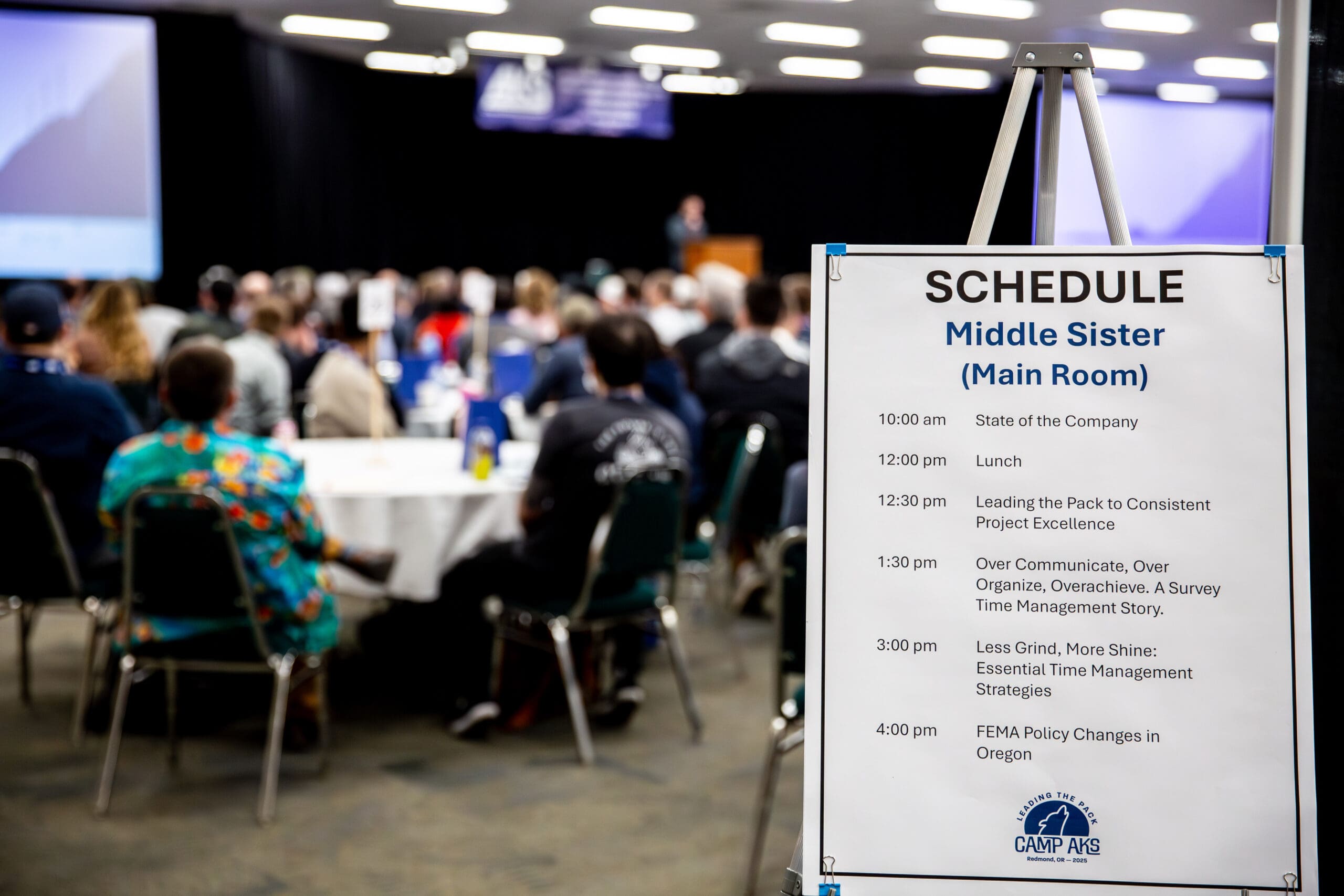 A close-up of the Camp AKS 2025 session schedule highlights professional development opportunities for civil engineers and surveyors during the company retreat in Redmond, Oregon.