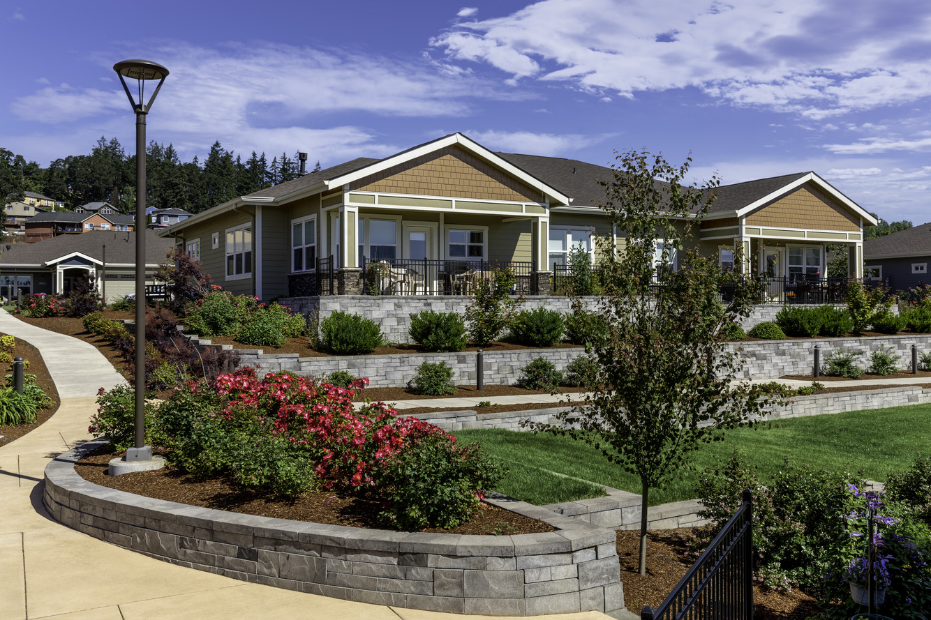 Photo of Capital Manor townhomes, retaining walls with landscaping, and a walking path