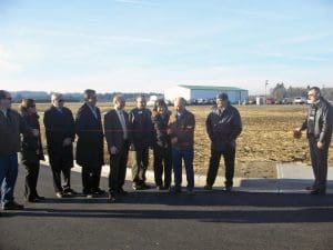 A photo of several people gathered at an industrial development ribbon-cutting ceremony